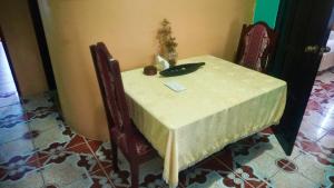 ベリーズシティにあるSee Belize WATERSIDE Sea View Apt for 6 with Kitchen, Balcony, Infinity POOL & Overwater Deck, 2nd Floorの白いテーブルクロスと花瓶が置かれたテーブル