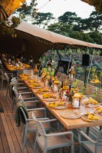 a long wooden table with chairs and plates of food at The Alexander Estate in Noordhoek