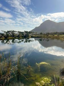 a body of water with a mountain in the background at The Alexander Estate - Cape Point Vineyard, Noordhoek in Noordhoek