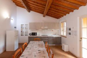 eine Küche mit einem langen Tisch und Stühlen in einem Zimmer in der Unterkunft Agriturismo La Gatta E L'Olivo in Donoratico
