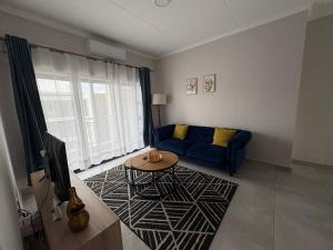 a living room with a blue couch and a table at Haven & Beyond in Gaborone