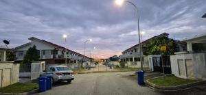 a car parked in a parking lot next to houses at Wonder Villa in Bandar Penawar