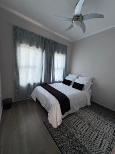 a bedroom with a bed and a ceiling fan at Haven & Beyond in Gaborone