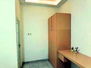 a room with a desk and a cabinet in it at Casa Bella Homestay in Palembang