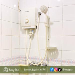 eine Dusche im Bad mit einer weiß gefliesten Wand in der Unterkunft City View 2BR Home in Burnham - Dalisay Unit by Balay Paz in Baguio City + 57 Fotos