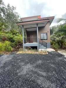 ランタ島にあるBaan klang suan at kantiang bayの砂利道沿いのバルコニー付きの小さな家