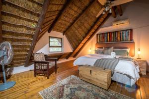 a bedroom with a bed and a desk and a fan at Nzenga Lodge in Hoedspruit +148 photos