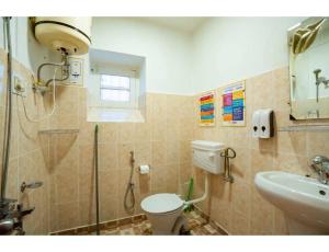 um banheiro com chuveiro, vaso sanitário e pia em goSTOPS Srinagar em Srinagar mais 52 fotografias