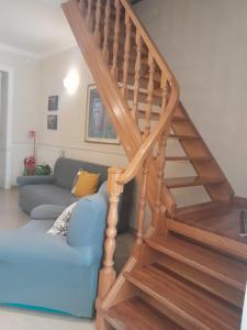a wooden staircase with a blue couch in a living room at Casa ERMES 151 in Floridia +22 photos