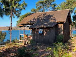 an old shack with a chair in front of a lake at TSIAZOMPANIRY ISLAND LODGE in Ambohimiadana