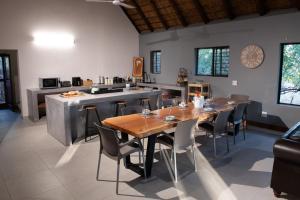 a kitchen and dining room with a table and chairs at Nzenga Lodge in Hoedspruit