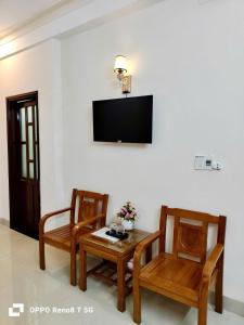 a living room with two chairs and a table and a tv at Motel Rose in Hue