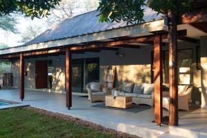a pavilion with couches and chairs on a patio at Nzenga Lodge in Hoedspruit