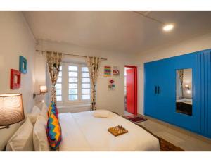 um quarto com uma cama branca e uma parede azul em goSTOPS Srinagar em Srinagar