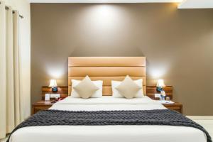 a bedroom with a large bed with two lamps at The Avenue Hotel & Banquet Near Bhopal Junction in Bhopal