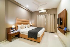 a hotel room with a bed and a television at The Avenue Hotel & Banquet Near Bhopal Junction in Bhopal