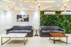 a lobby with two couches and a green wall at The Avenue Hotel & Banquet Near Bhopal Junction in Bhopal