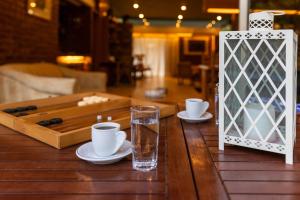 a wooden table with two cups and a glass of water at Retro House in Rafina