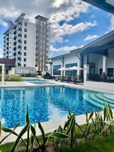 a large swimming pool in front of a building at Azure Edge in Dauis