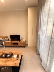 una sala de estar con un televisor y una mesa en Fillio's Apartment 2, Ptolemaida, en Ptolemaida
