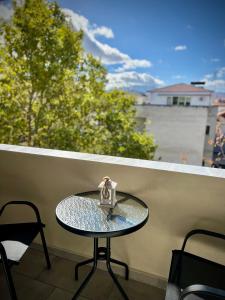 een glazen tafel met een klein beeldje op een balkon bij Fillio's Apartment 2, Ptolemaida in Ptolemaida