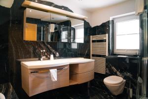 um banheiro com uma pia, um vaso sanitário e um espelho em Relax in Thaur em Thaur mais 35 fotografias