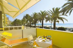 uma mesa e cadeiras com vista para a praia em Hotel Internazionale em Finale Ligure