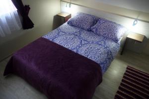 sypialnia z fioletowym łóżkiem z 2 poduszkami w obiekcie Wypoczynkowa Osada domki blisko morza w Jastrzębiej Górze