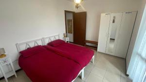 a bedroom with a large bed with a red blanket at Appartamento Torre 