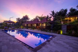 a villa with a swimming pool at dusk at Pondok Tegal Tunon Villa Ubud Bali in Ubud