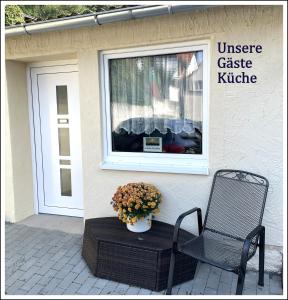a chair and a vase of flowers next to a window at Herr Berge in Fritzlar