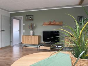 a living room with a flat screen tv on a wall at Ferienwohnung Schreiter in Arnsfeld