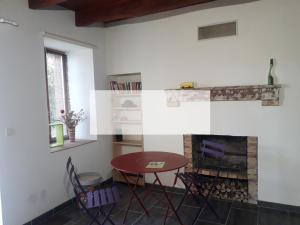 una sala de estar con una mesa y una chimenea en Odyssée-Auvergne, en Vallon-en-Sully