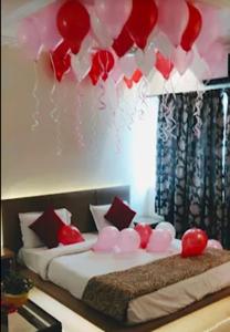 a room with two beds with red and white balloons at Hotel International, Kolhapur in Kolhapur