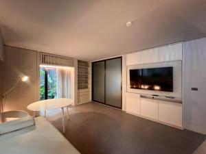 uma sala de estar com uma televisão e uma mesa em Tree Villa Bangkok em Banguecoque mais 32 fotografias