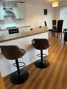 a kitchen with two bar stools and a counter at Caledonian Apartment in Perth +11 photos