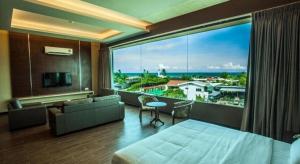 een slaapkamer met een groot raam met uitzicht op de oceaan bij Friendly Hotel in Kudat