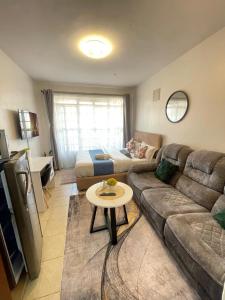 a living room with a couch and a table at Habun Homes in Ruaka