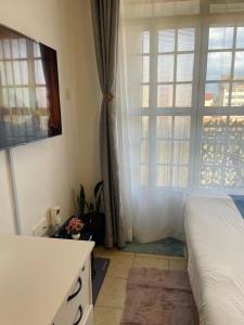 a bedroom with a bed and a large window at Habun Homes in Ruaka +1 photo