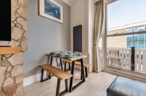 een eetkamer met een tafel en een groot raam bij Ocean view in Swanage