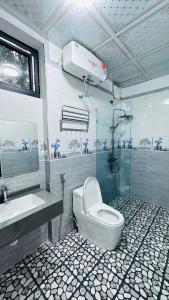 ein Badezimmer mit Toilette, Waschbecken und Dusche in der Unterkunft Là Nhà Homestay in Hữu Lũng