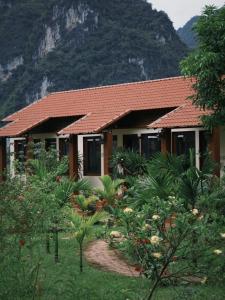 ein Haus mit einem Garten vor einem Berg in der Unterkunft Là Nhà Homestay in Hữu Lũng