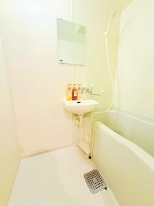 a white bathroom with a sink and a bath tub at Jaunty 130 Room 205 in Fukuoka +18 photos