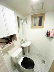 a white bathroom with a toilet and a sink at Like a local resident near a major tourist attraction in Gyeongju, can store luggage in Gyeongju
