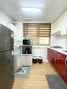 a kitchen with red cabinets and a black refrigerator at Like a local resident near a major tourist attraction in Gyeongju, can store luggage in Gyeongju