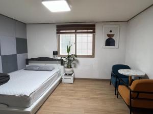 a bedroom with a bed and a table and a window at Like a local resident near a major tourist attraction in Gyeongju, can store luggage in Gyeongju