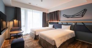 Una cama o camas en una habitación de QuintessaHotel Osakaumeda Comic&Books