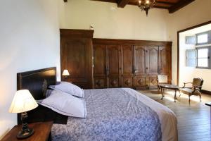 1 dormitorio con 1 cama con lámpara y silla en Chateau de Lugagnac, en Rivière-sur-Tarn