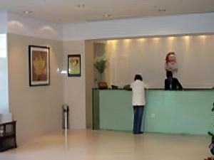 two people standing at a counter in a room at Jinjiang Inn Select Yangzhou Shouxi Lake Siwangting Road in Yangzhou