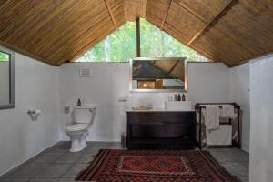 een badkamer met toilet, wastafel en raam bij Ichingo Chobe River Lodge by Mantis in Punga +67 foto's